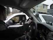 Clark County Sheriff’s deputies Alex O’Hearn, foreground, and Melissa Sager compare notes while searching for a stolen car in the Orchards area of Vancouver. The deputies are two of the department’s newest hires.