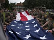 Volunteers lend a hand as they help to unfold and hoist the Garrison Flag during the 2019 Memorial Day service at Fort Vancouver National Historic Site on Monday.