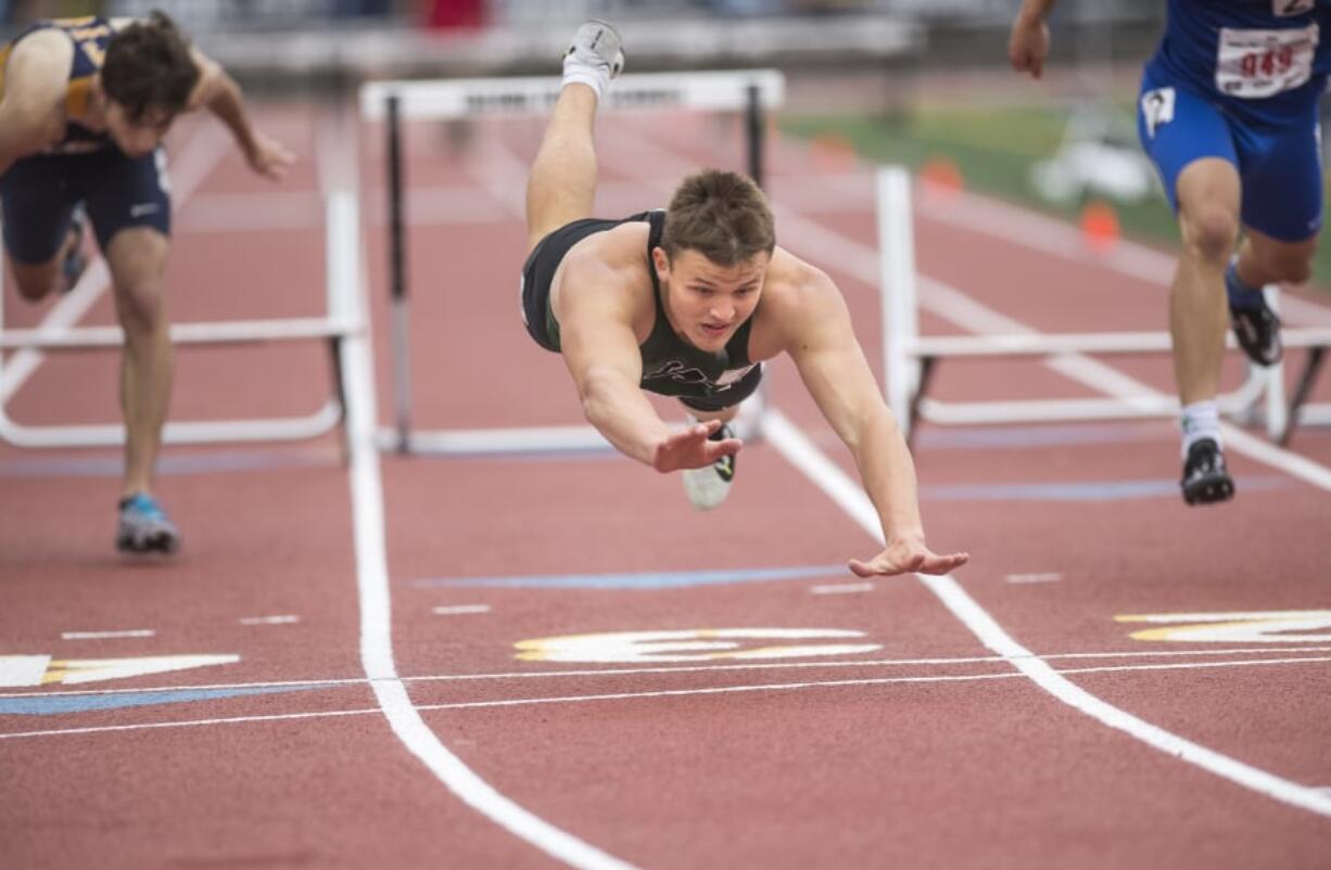 Woodland’s Tyler Flanagan dives across the finish line to beat a competitor in an out-of-frame lane in the 2A 300 Meter Hurdles during the WIAA state track meet in Tacoma.