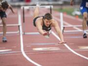 Woodland’s Tyler Flanagan dives across the finish line to beat a competitor in an out-of-frame lane in the 2A 300 Meter Hurdles during the WIAA state track meet in Tacoma.