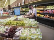 Produce Manager Phillip Ferrier stocks fresh grapes at New Seasons Market in Vancouver. Almost half of U.S. consumers grocery shop online, according to a recent survey by KPMG, a network of professional service firms.