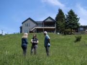 Homeowners Julie Zanzi, left, and John Zanzi talk with Clark Conservation District resource specialist Ashley Smithers on how to use local plants to make a field of grass near their home more environmentally friendly. The Zanzis participated in a six-week class on watershed stewardship that the conservation district offers.