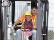 Liah Hansen-Bruen operates an excavator with help from Frank Lott at Dozer Day in 2019.