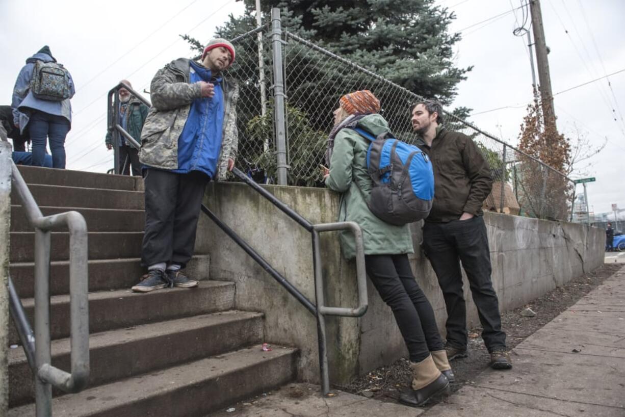 Dimitri Coles, left, speaks with Katelyn Benhoff and Blake Hauser, outreach case managers with Share on Jan. 24 during the annual Point in Time Count.