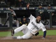 Seattle Mariners' Domingo Santana scores on a walk-off single hit by Omar Narvaez during the 10th inning of a baseball game against the Oakland Athletics, Monday, May 13, 2019, in Seattle. The Mariners won 6-5 in 10 innings. (AP Photo/Ted S.