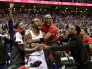 Toronto Raptors forward Kawhi Leonard, second from left, celebrates his game-winning basket as time expired at the end of an NBA Eastern Conference semifinal basketball game against the Philadelphia 76ers, in Toronto on Sunday, May 12, 2019. Toronto won 92-90.