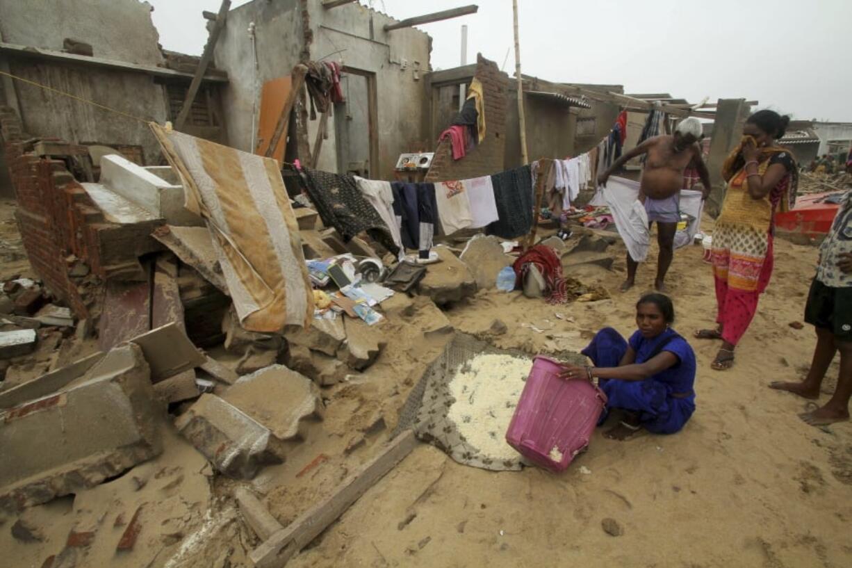 Locals stand by damage made by Cyclone Fani in the Penthakata fishing village of Puri, in the eastern Indian state of Orissa, Saturday, May 4, 2019. A mammoth preparation exercise that included the evacuation of more than 1 million people appears to have spared India a devastating death toll from one of the biggest storms in decades, though the full extent of the damage was yet to be known, officials said Saturday.