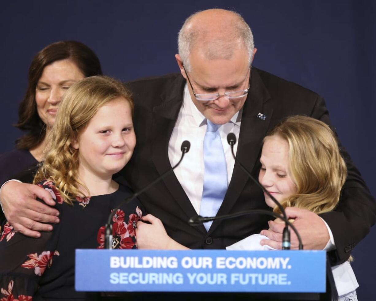 Australian Prime Minister Scott Morrison, center, embraces his daughters Lily, right, and Abbey, after his opponent concedes defeat in the federal election in Sydney, Australia, Sunday, May 19, 2019.