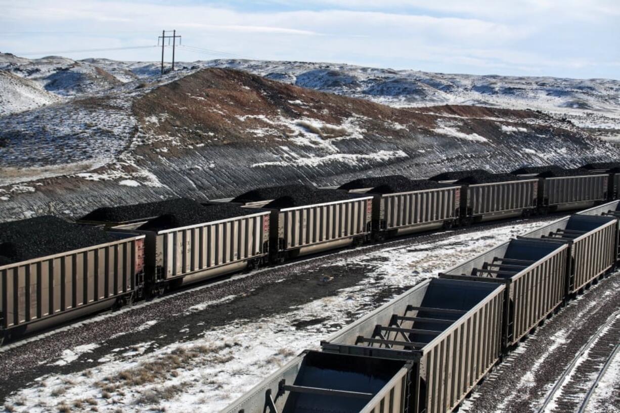 Rail cars are filled with coal and sprayed with a topper agent to suppress dust at Cloud Peak Energy’s Antelope Mine north of Douglas, Wyo., in January 2014.