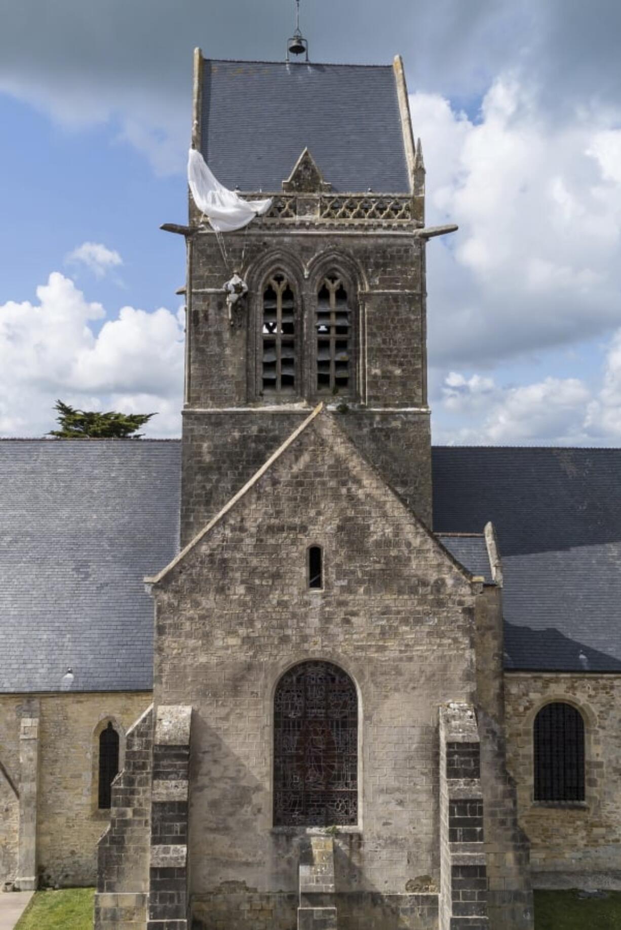 In this photo taken with a drone, a dummy paratrooper representing a WWII paratrooper from the 82nd Airborne hangs on the bell tower of the church of Sainte Mere Eglise, in Normandy, France, Thursday, May 9, 2019. Seventy-five years ago, American paratrooper John Steele dangled from a clock tower in Sainte-Mere-Eglise after his parachute got caught during the D-Day invasion, and survived.