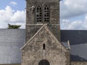 In this photo taken with a drone, a dummy paratrooper representing a WWII paratrooper from the 82nd Airborne hangs on the bell tower of the church of Sainte Mere Eglise, in Normandy, France, Thursday, May 9, 2019. Seventy-five years ago, American paratrooper John Steele dangled from a clock tower in Sainte-Mere-Eglise after his parachute got caught during the D-Day invasion, and survived.