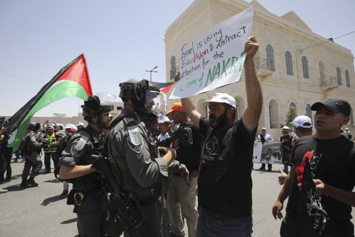 A man holding anti-Eurovision banner confronts an Israeli border policeman as Palestinian marked the 71st anniversary of their mass displacement during the 1948 war around Israel’s creation.