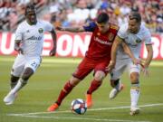 Portland Timbers midfielders Diego Chara (21) and Sebastian Blanco (10) pressure Real Salt Lake forward Jefferson Savarino during an MLS soccer match Saturday, May 4, 2019, in Sandy, Utah.