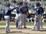 Seattle Mariners’ Scott Servais, left, calls for a new pitcher as Yusei Kikuchi, center, is removed in the fourth inning of a baseball game against the Oakland Athletics, Saturday, May 25, 2019, in Oakland, Calif.