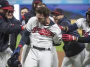 Cleveland Indians’ Tyler Naquin, center, is mobbed by teammates after hitting a winning RBI-single off Seattle Mariners relief pitcher Anthony Swarzak in the ninth inning of a baseball game in Cleveland, Friday, May 3, 2019.