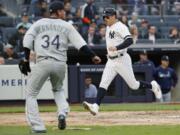 New York Yankees’ Mike Tauchman scores on DJ LeMahieu’s second-inning single as Seattle Mariners starting pitcher Felix Hernandez (34) heads toward the plate during a baseball game, Monday, May 6, 2019, in New York.