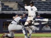 Seattle Mariners catcher Tom Murphy, left, tries to corral the throw as New York Yankees’ Cameron Maybin runs home to score on a game-winning RBI single by DJ LeMahieu during the ninth inning of a baseball game, Tuesday, May 7, 2019, in New York. The Yankees won 5-4.