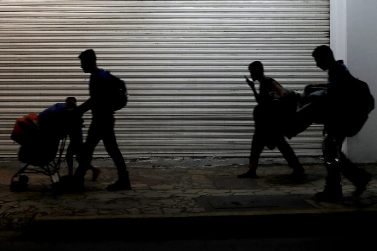 Migrant families camped in a park leave in the middle of the night as they are pushed out by Mexican immigration authorities, in Tapachula, Mexico, early Wednesday, May 29, 2019. Authorities cleared the park of camping Central American migrants and the makeshift encampment of Haitians and African migrants outside the immigration detention center near the Guatemala border.