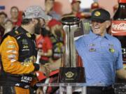 Martin Truex Jr., left, is congratulated by team owner Joe Gibbs in Victory Lane after winning the NASCAR Cup Series auto race at Charlotte Motor Speedway in Concord, N.C., Sunday, May 26, 2019.