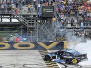 Driver Martin Truex Jr. (19) performs a burnout after winning the NASCAR Cup Series auto race, Monday, May 6, 2019, at Dover International Speedway in Dover, Del.