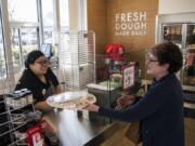 Papa Murphy’s store manager Gladys Marron helps Jo Olson of Vancouver on March 15 at Papa Murphy’s on Southeast Mill Plain Boulevard.