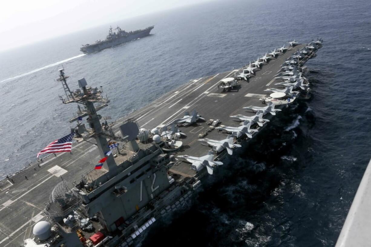 The USS Abraham Lincoln sails in the Arabian Sea near the amphibious assault ship USS Kearsarge. Commercial airliners flying over the Persian Gulf risk being targeted by “miscalculation or misidentification” from the Iranian military amid heightened tensions between the Islamic Republic and the U.S., American diplomats warned Saturday, May 18, 2019, even as both Washington and Tehran say they don’t seek war. (Mass Communication Specialist 1st Class Brian M. Wilbur, U.S.