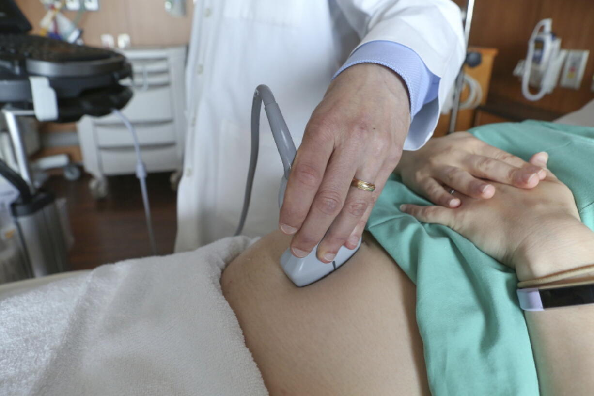 FILE - In this Aug. 7, 2018 file photo, a doctor performs an ultrasound scan on a pregnant woman at a hospital in Chicago. According to a report released by the Centers for Disease Control and Prevention on Tuesday, May 7, 2019, in about 17 out of every 100,000 U.S. births each year, the mother dies from pregnancy-related causes - around 700 deaths a year. But the rate has been slowly climbing for decades. The rate was around 12 per 100,000 a quarter century ago.