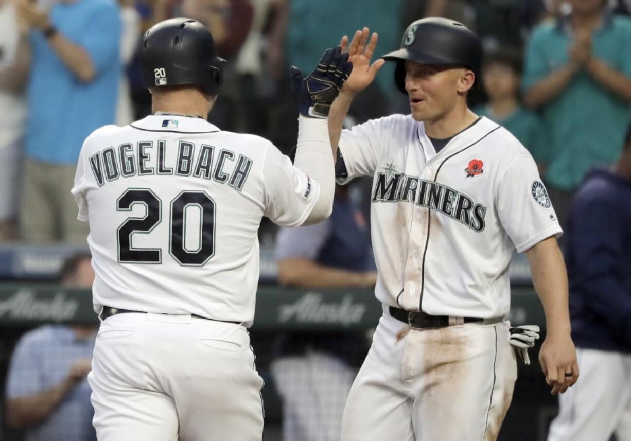 Seattle Mariners’ Daniel Vogelbach (20) is greeted at the dugout by Kyle Seager after Vogelbach hit a two-run home run against the Texas Rangers during the seventh inning of a baseball game, Monday, May 27, 2019, in Seattle. (AP Photo/Ted S.