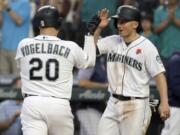 Seattle Mariners’ Daniel Vogelbach (20) is greeted at the dugout by Kyle Seager after Vogelbach hit a two-run home run against the Texas Rangers during the seventh inning of a baseball game, Monday, May 27, 2019, in Seattle. (AP Photo/Ted S.