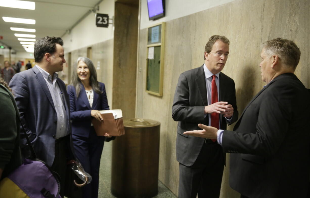 In this photo taken Tuesday, May 21, 2019, from left, David Snyder, an attorney with the First Amendment Coalition, attorney Duffy Carolan, and Thomas Burke, attorney for freelance journalist Bryan Carmody, talk outside a courtroom before a hearing in San Francisco. Advocates of the press pushed back against a San Francisco police chief who said a freelance journalist had “crossed the line” in conspiring to steal a police report, saying that it is not a crime to disclose a public record. Carolan, who is representing several media organizations siding with the independent reporter, says that the public has constitutional rights to access public records.