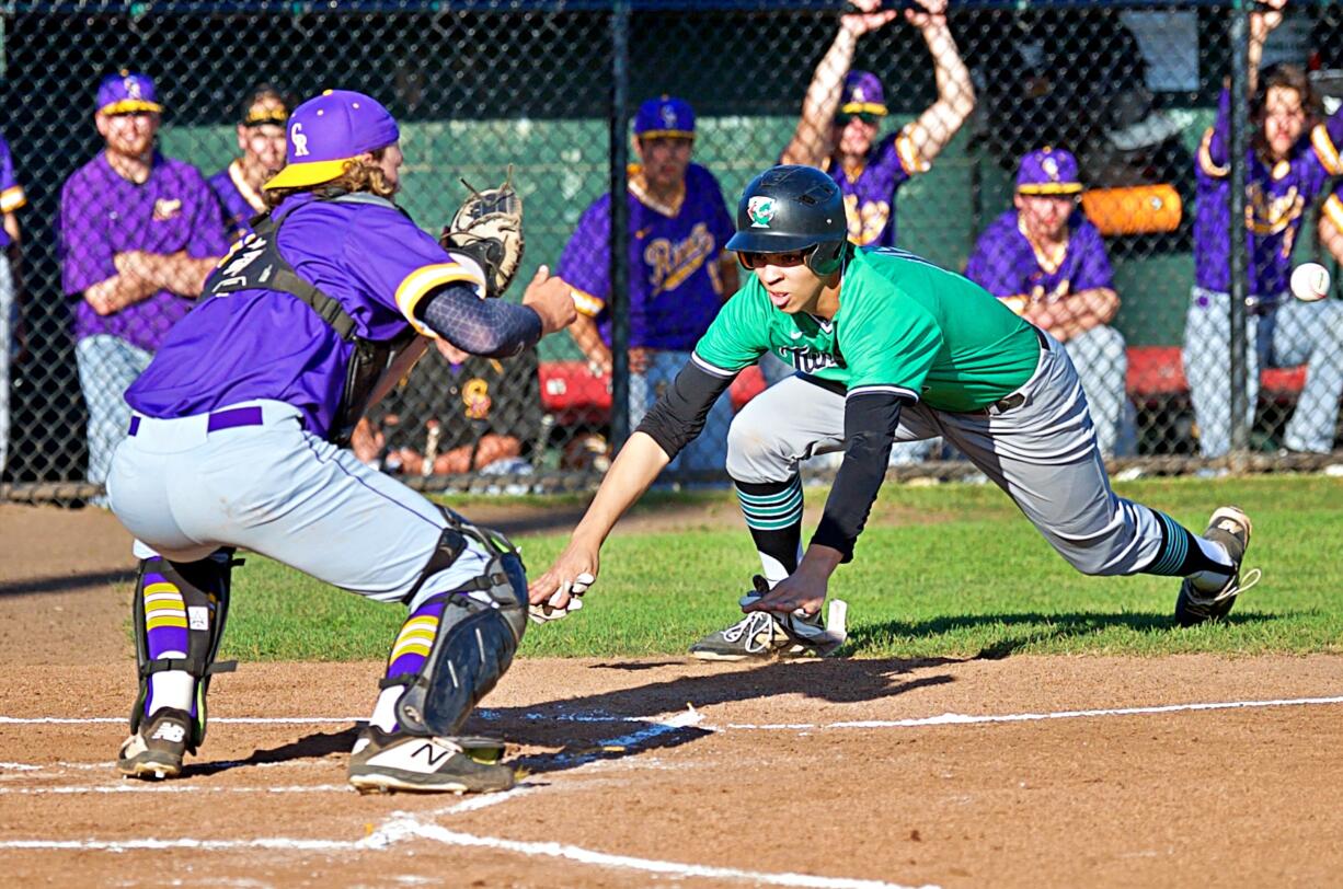 Columbia River catcher Xavier Ulrich receivers the throw from left fielder Cole Delich to tag out Tumwater's Damon Gaither in a 2A district semifinal baseball game Wednesday at Ed Wheeler Field in Centralia. Columbia River won 10-4.