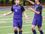 Columbia River's Jake Connop gestures toward his teammates as Sideris Kosaris comes to congratulate him on his second goal of a 2A state quarterfinal game Saturday at Chieftain Stadium. Columbia River won 4-1.