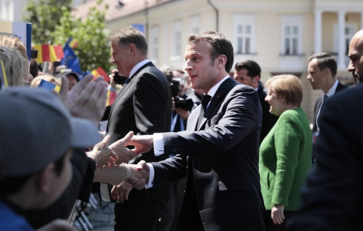 French President Emmanuel Macron, center, greets the public after a group photo of EU leaders at an EU summit in Sibiu, Romania, Thursday, May 9, 2019. European Union leaders on Thursday start to set out a course for increased political cooperation in the wake of the impending departure of the United Kingdom from the bloc.