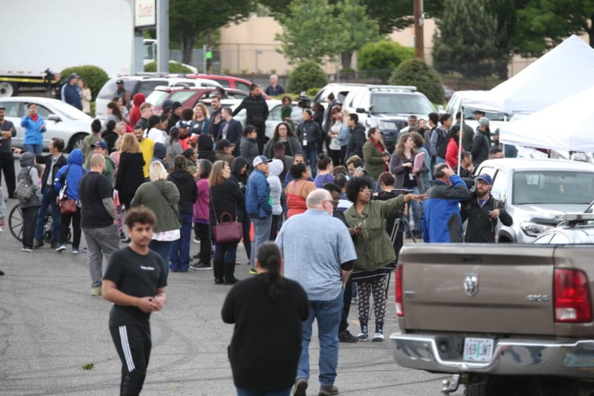 Students gather outside Parkrose High School in Portland on Friday after a man armed with a gun was wrestled to the ground by a staff member.