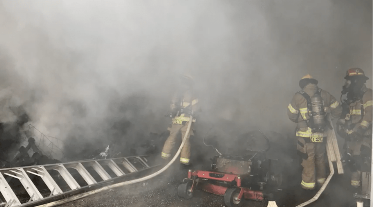 Firefighters battle an outbuilding fire on a property in Ridgefield on Wednesday morning.