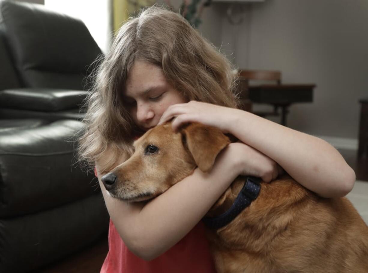 Sobie Cummings, 11, plays with her dog, Dallas, at the family’s home in Waxhaw, N.C., Friday, March 29, 2019. A psychiatrist suggested that a service dog might help to ease Sobie’s crippling anxiety and feelings of isolation. But when they brought home a $14,500 Briard from Mark Mathis’ Ry-Con Service Dogs, Okami broke from Glenn Cummings’ grasp and began mauling Dallas.