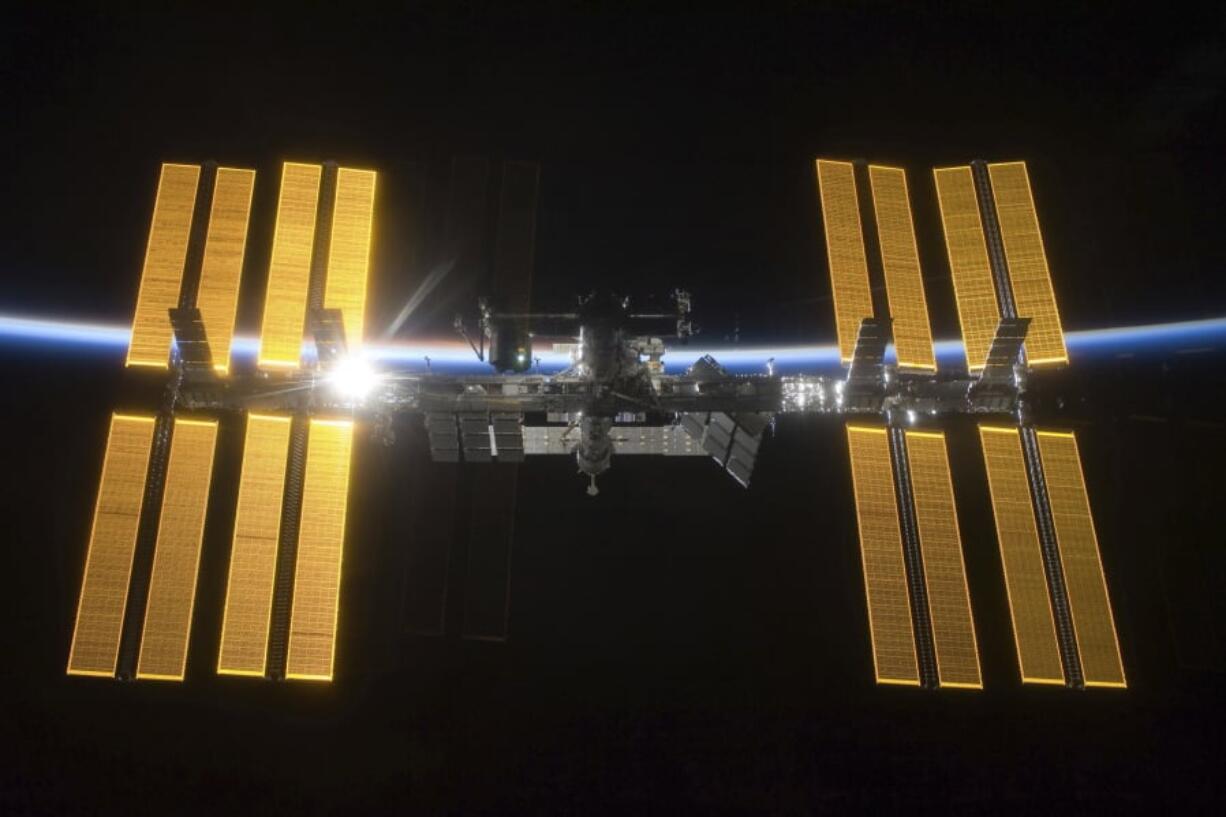 This March 25, 2009 photo provided by NASA shows the International Space Station seen from the Space Shuttle Discovery during separation. In the background is Earth’s atmosphere seen as a blue arc. On Tuesday, April 30, 2019, NASA announced that a major power shortage at the station has delayed a SpaceX supply run later in the week.