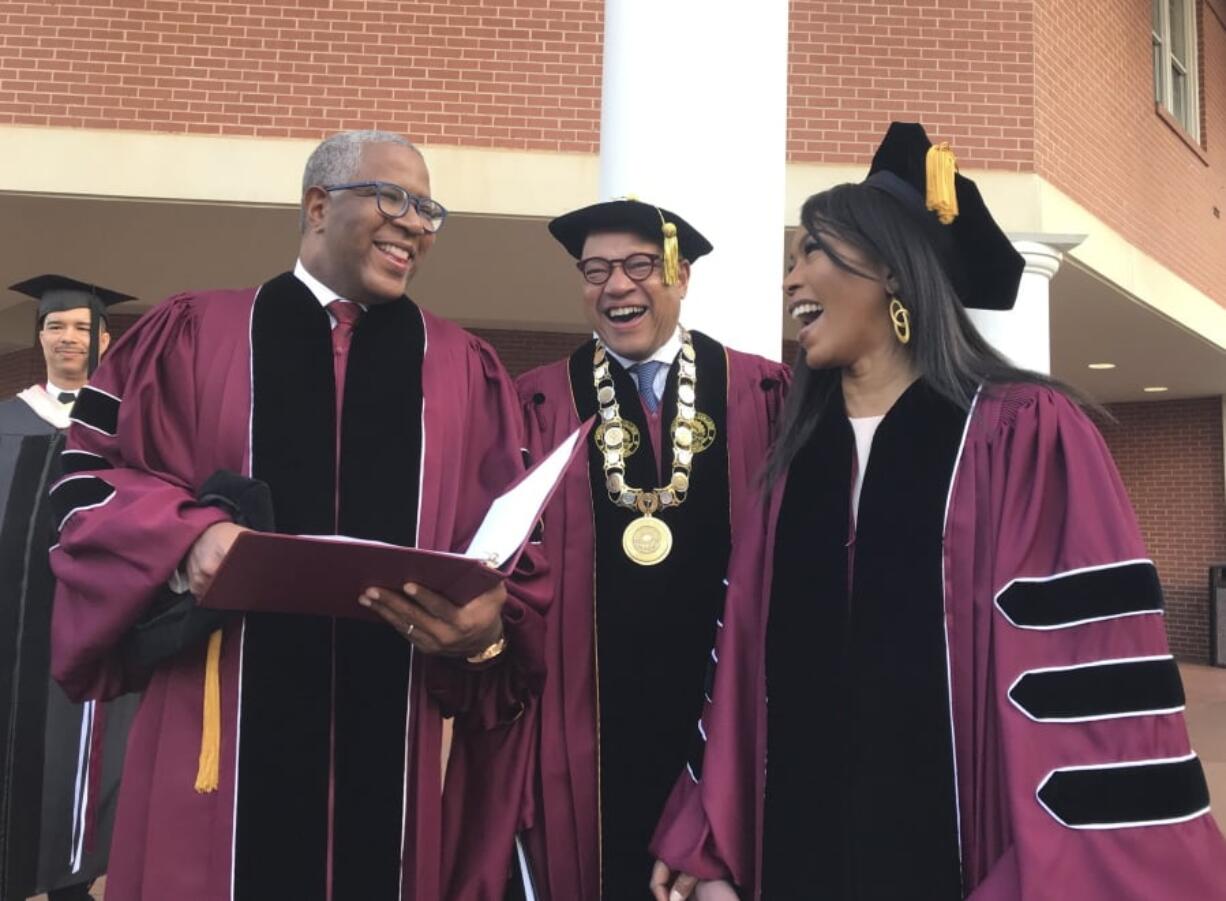 Robert F. Smith, left, laughs with David Thomas, center, and actress Angela Bassett at Morehouse College on Sunday, May 19, 2019, in Atlanta. Smith, a billionaire technology investor and philanthropist, said he will provide grants to wipe out the student debt of the entire graduating class at Morehouse College - an estimated $40 million. Smith, this year’s commencement speaker, made the announcement Sunday morning while addressing nearly 400 graduating seniors of the all-male historically black college in Atlanta.