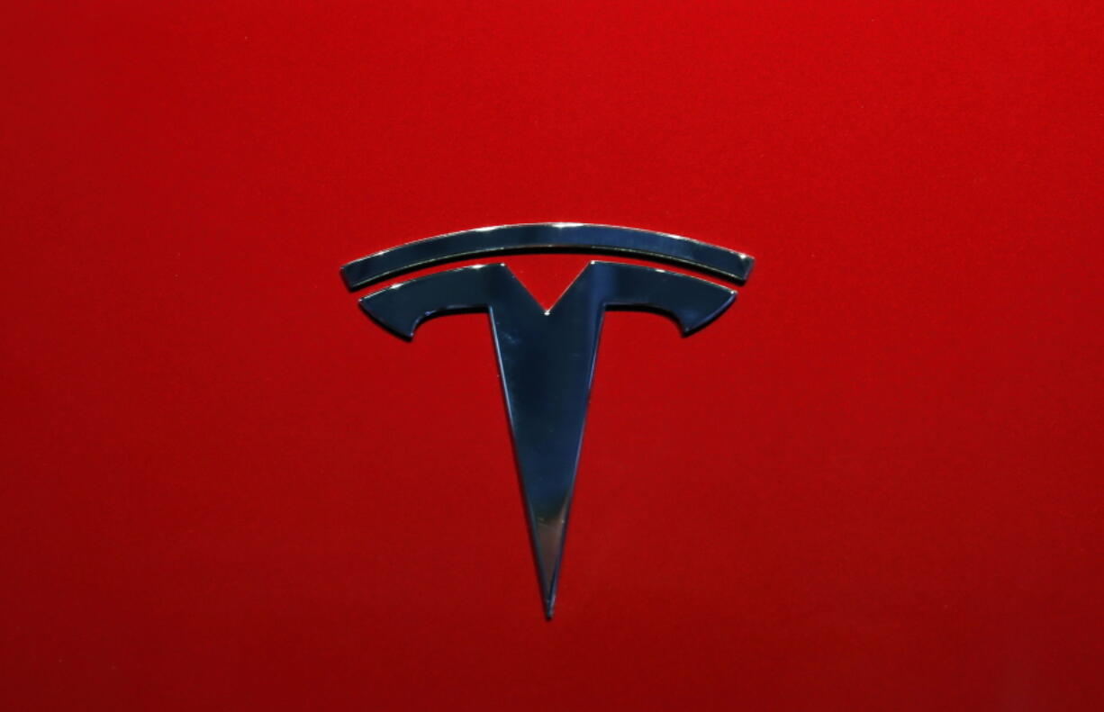 FILE- This Oct. 3, 2018, file photo shows the logo of Tesla model 3 at the Auto show in Paris. The National Transportation Safety Board says Tesla’s Autopilot semi-autonomous driving system was in use when one of its cars drove beneath a semitrailer in Florida in March, killing the driver.