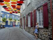 Paule Bergeron takes in the scene in Place-Royale in Old Quebec, Aug. 27, 2018. Quebec City offers compelling urban bike routes along the river, out to Montmorency Falls and through intriguing neighborhoods, as well as access to the Jacques-Cartier rail trail running through forest, farmland and meadows.