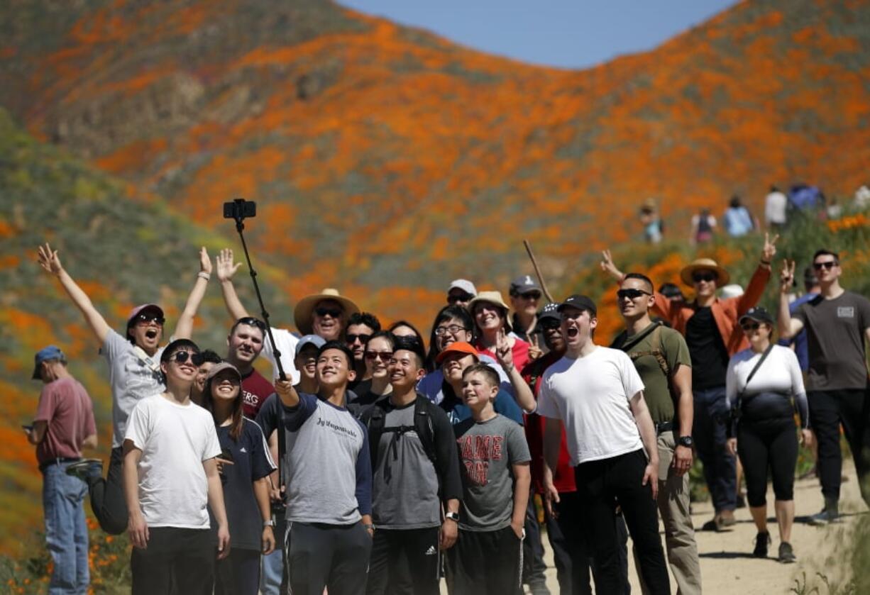 People pose for a picture among wildflowers in bloom March 18 at Lake Elsinore, Calif. This spring, fields of wildflowers in Lake Elsinore, were overrun by tourists seeking the perfect photo.