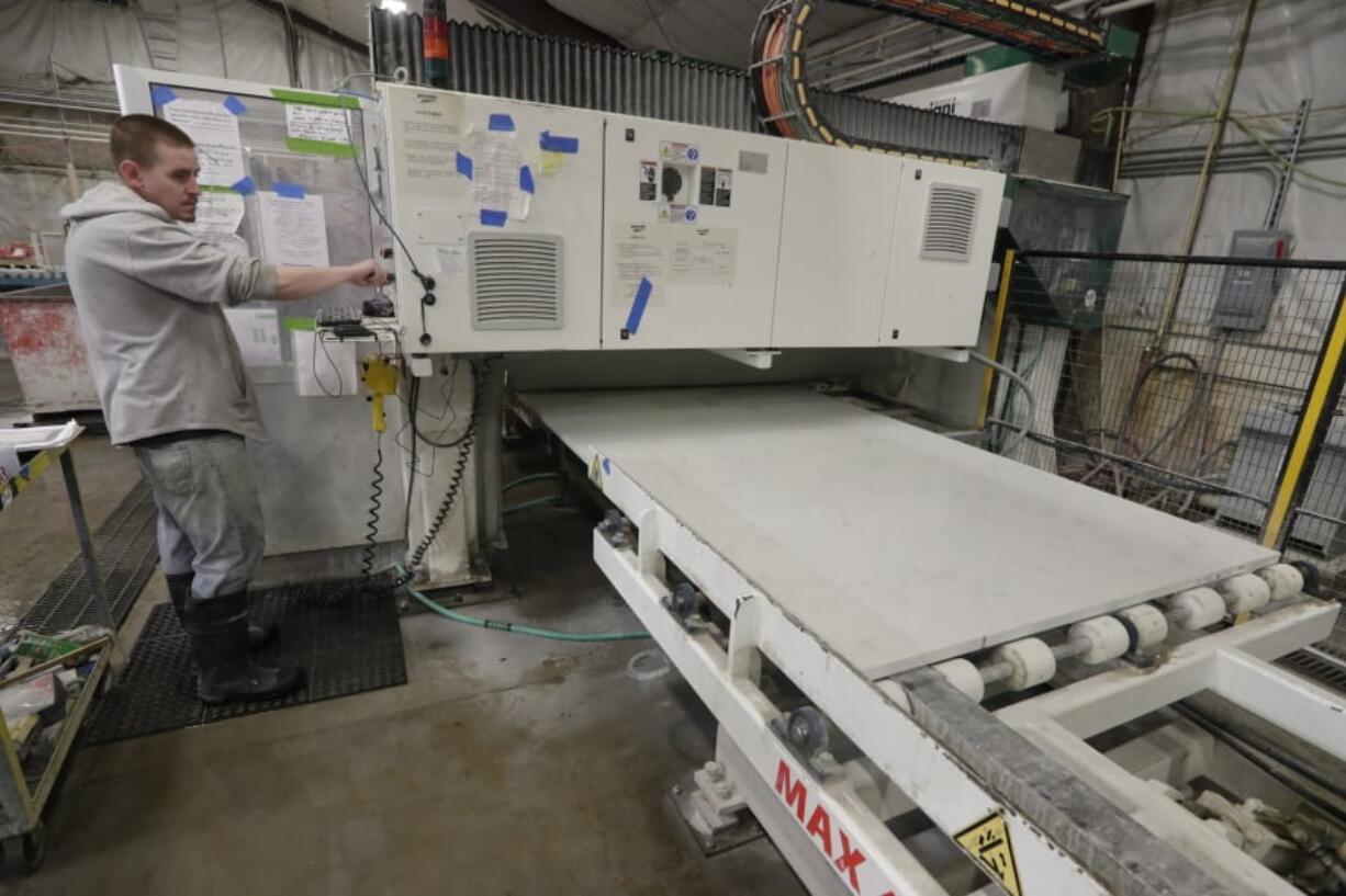 A worker begins production of a kitchen countertop that is being cut from imported quartz slabs from China in the production facility at Marble Uniques in Tipton, Ind., Friday, May 3, 2019. The Trump administration's trade warriors are fighting obscure battles over laminated woven sacks from Vietnam, for example, olives from Spain and rubber bands from Thailand. The International Trade Commission in Washington this week will provide an arena for combat over kitchen and bathroom countertops -- or at least the imported quartz slabs that many of them come from.