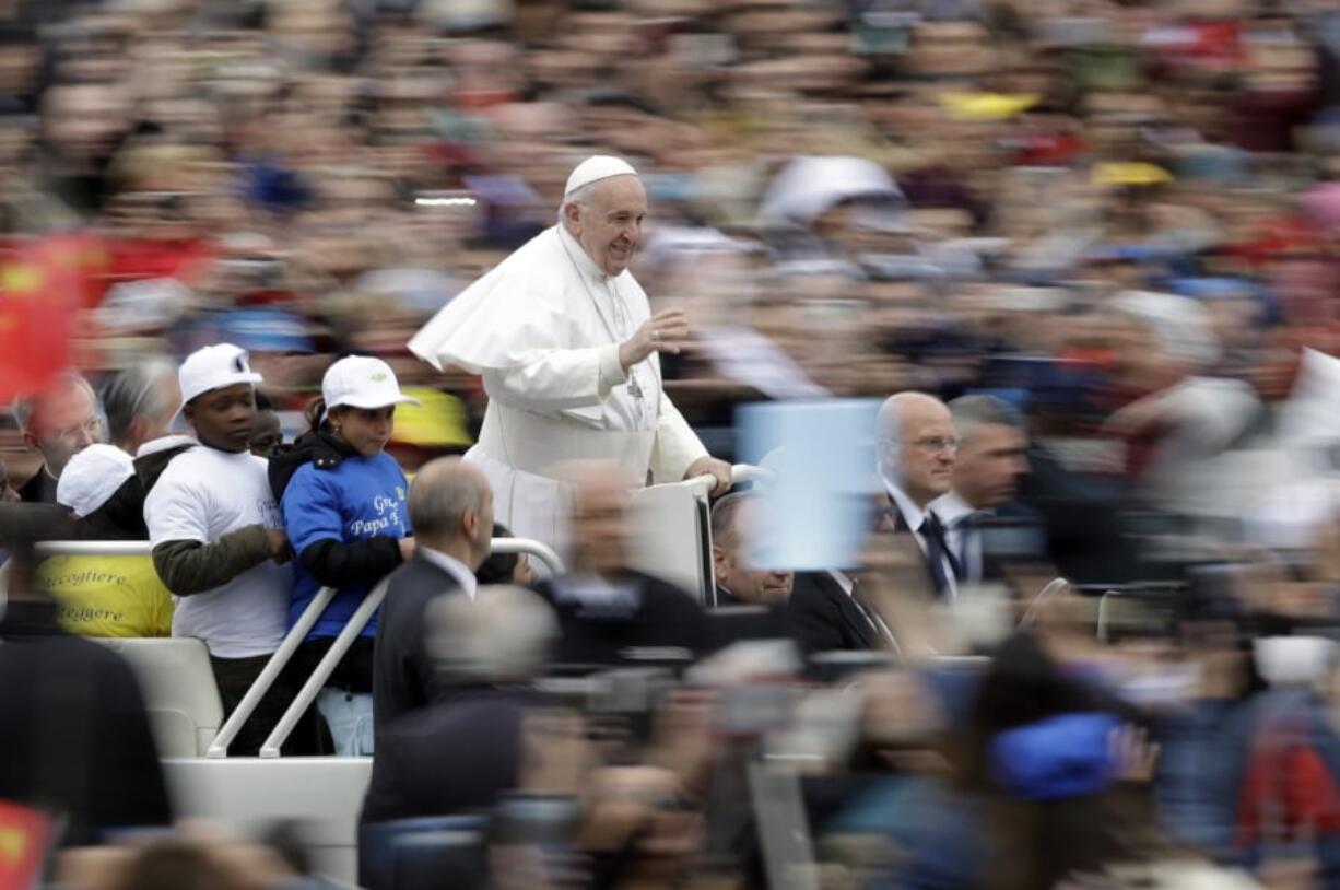 Pope Francis rides with a group of migrant children who recently arrived from Libya, on his popemobile at the start of his weekly general audience in St. Peter’s Square, at the Vatican, Wednesday May 15, 2019.