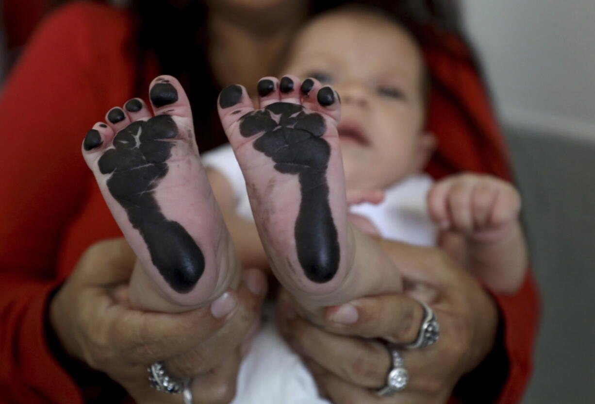 Arelys Pulido holds her two-month-old daughter Zuleidys Antonella Primera after she had her feet prints taken for her birth certificate at the Erazmo Meoz hospital in Cucuta, on Colombia’s border with Venezuela, Thursday, May 2, 2019. Colombia’s government grants newborns like Zuleidys Antonella Primera, born of illegal Venezuelan migrants, full health care during the first year of life and allows them to enroll in school, but experts on statelessness fear that if Venezuela’s crisis drags on for years, they could approach adulthood without key rights such as the ability to travel legally, buy property or get married.