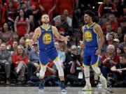 Golden State Warriors guard Stephen Curry, left, and guard Quinn Cook react after Curry made a basket against the Portland Trail Blazers during the second half of Game 4 of the NBA basketball playoffs Western Conference finals Monday, May 20, 2019, in Portland, Ore. The Warriors won 119-117 in overtime.