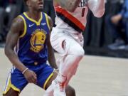 Portland Trail Blazers guard Damian Lillard, right, shoots past Golden State Warriors forward Jordan Bell during the first half of Game 4 of the NBA basketball playoffs Western Conference finals Monday, May 20, 2019, in Portland, Ore.