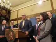 Gov. Jay Inslee, surrounded by Democratic lawmakers from the Senate and House, talks to the media Monday after the Legislature adjourned its 105-day session in Olympia.