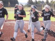 From left to right, Woodland's Olivia Grey, Kailey Christensen, Carleigh Risley and Justice Holcomb run to celebrate Payten Foster's two-run home run Friday at the Ridgefield Outdoor Recreation Complex.