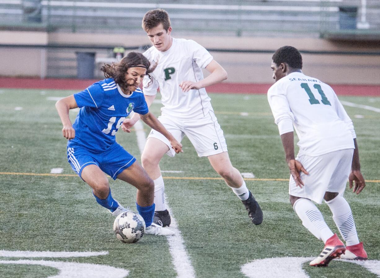 Mountain View's Elijah Thompson, left sidesteps Pensinsula's Austin Lee, back, and Kenneh Roberts in a 3A bi-district boys soccer game Tuesday at McKenzie Stadium. Peninsula won 2-1.