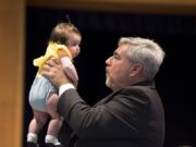 Clark College President Bob Knight holds up his 3-month-old granddaughter, Willow Knight, during his retirement party Thursday afternoon at the Vancouver campus.